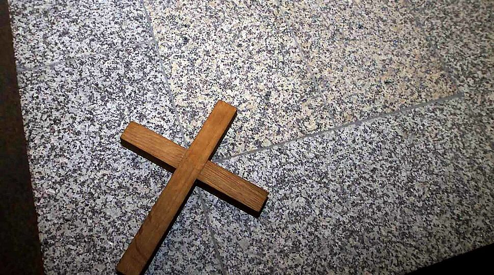 Ein schlichtes Holzkreuz auf einer Granitplatte Kirche-Staat_KNA_41331.jpg