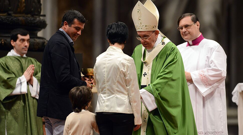 Papst Franziskus nimmt zu Beginn der Eucharistiefeier Gaben von Familien entgegen.  141005-93-000193.jpg