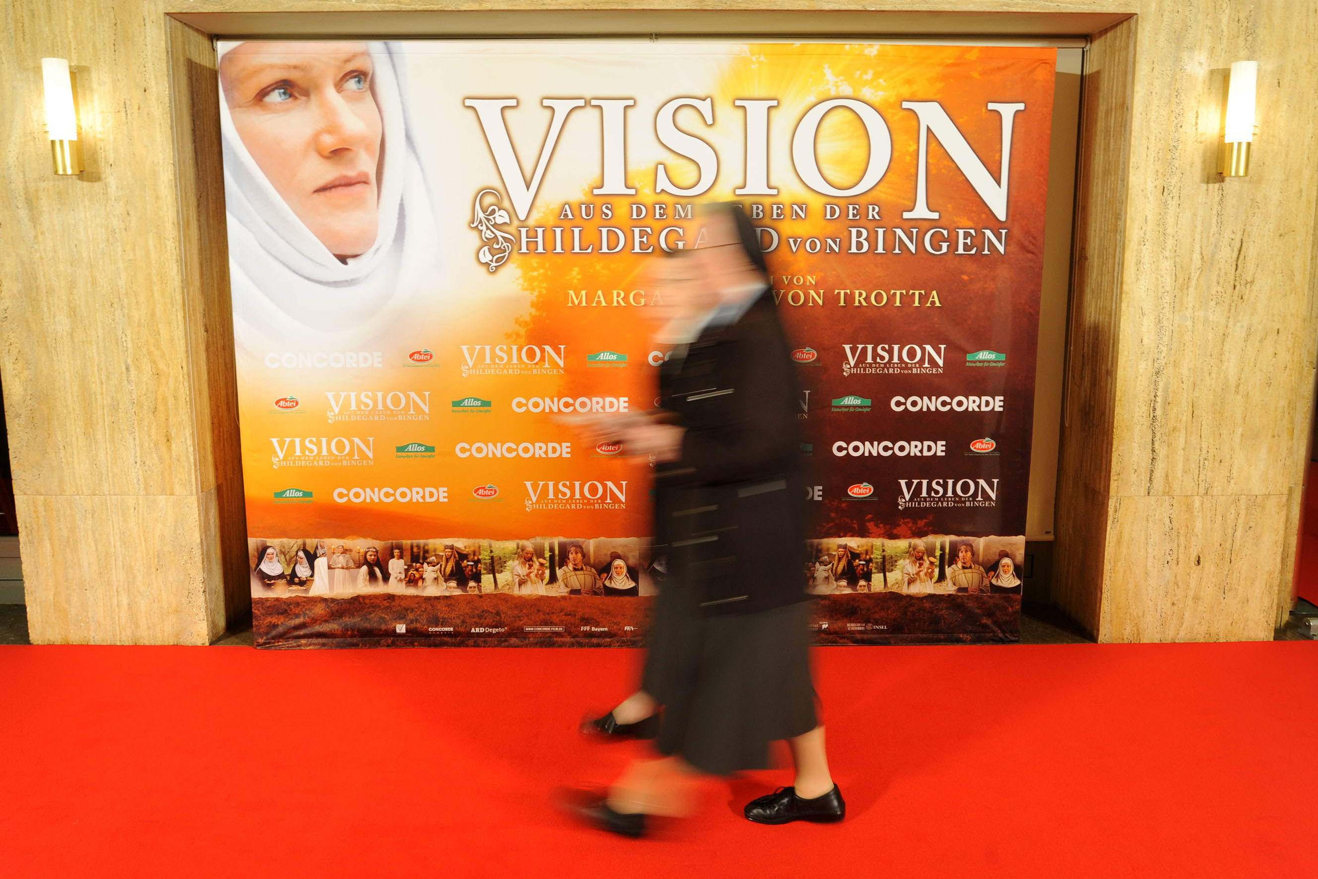 Eine Nonne läuft an einem Schaukasten mit dem Plakat zum Film vorbei